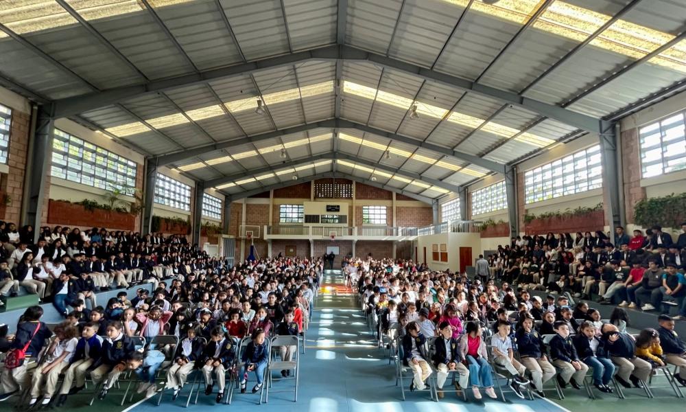 Reunión de estudiantes y personal dentro del gimnasio escolar.